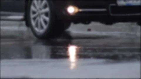 Splashes from car wheels on the road while driving through puddles in the city Stockbeeldmateriaal 314426090