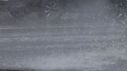 Splashes from car wheels on the road while driving through puddles in the city Stockbeeldmateriaal 314884878