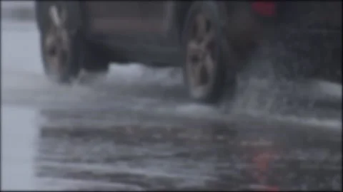 Splashes from car wheels on the road while driving through puddles in the city Stock Footage 314885589