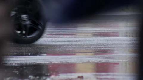 Splashes from car wheels on the road while driving through puddles in the city Stockbeeldmateriaal 315280740