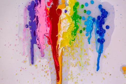 The splashes of color flow and droplets mixed together on white paper. Stock Photos