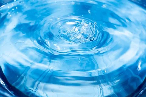 Splashes from a drop of water. Rain drops on a blue background. The texture o 库存照片