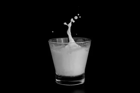 Splashes of milk on a black background Stock Photos