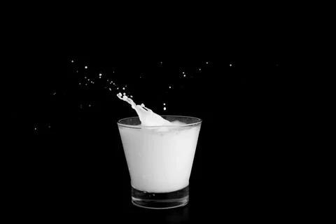 Splashes of milk on a black background Stock Photos