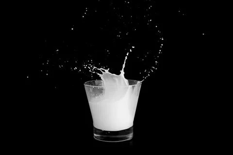 Splashes of milk on a black background Stock Photos