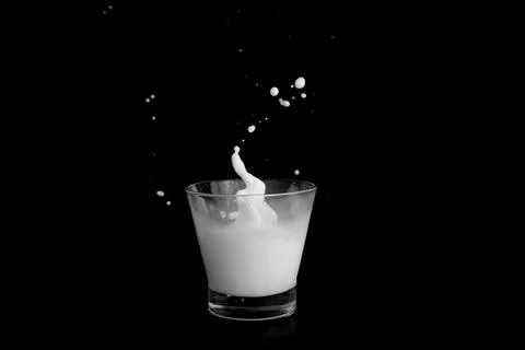 Splashes of milk on a black background Stock Photos