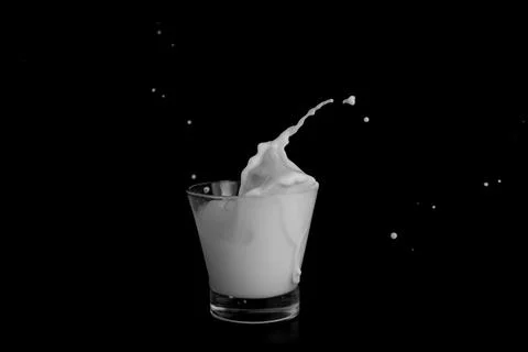 Splashes of milk on a black background Stock Photos