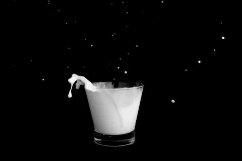 Splashes of milk on a black background Stock Photos