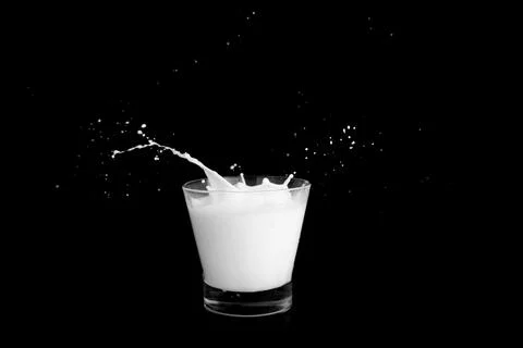 Splashes of milk on a black background Stock Photos