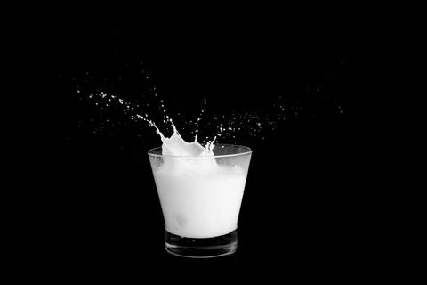 Splashes of milk on a black background Stock Photos