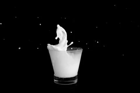 Splashes of milk on a black background Stock Photos
