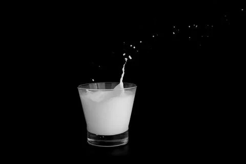Splashes of milk on a black background Stock Photos