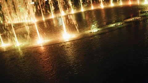 Splashes from the night fountain scatter around creating bizarre patterns Stock Footage 258453046