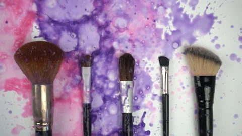 Splashes paints on makeup brushes in slow motion Stock Footage 99749475