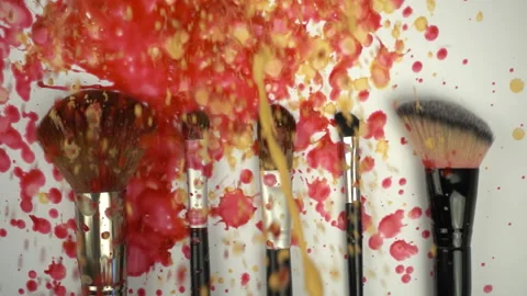 Splashes paints on makeup brushes in slow motion Stock Footage 99887451