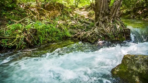 Splashes of rapid river current fly in the si 스톡 동영상 80999573