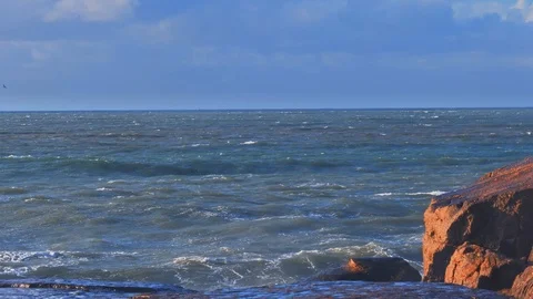 Splashes from the stormy waves bumping against the rocky shore Stock Footage 116178948