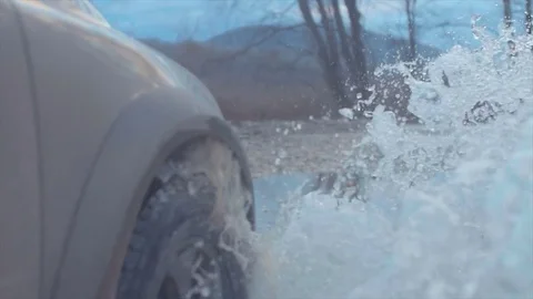 Splashes from under the wheels. Close up Slow motion. Country road. Stock-Footage 83997635