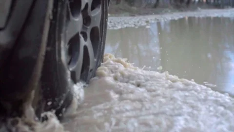 Splashes from under the wheels. Close up Slow motion. Country road. Video stock 84037957