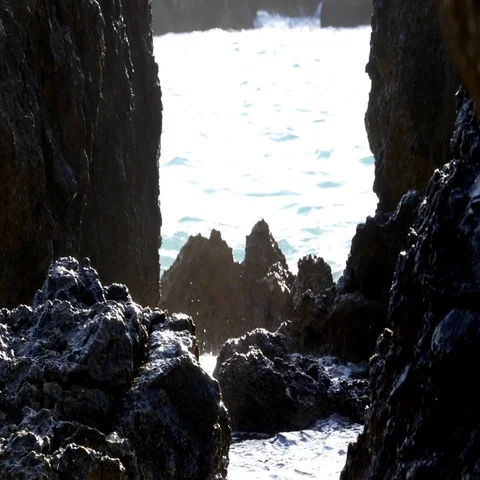 Splashes of water formed when waves break on the shore of steep boulde Stock Footage 69323242
