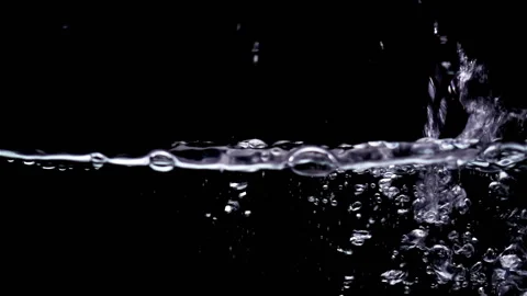 Splashes of water pouring in slow motion on a black Vídeo Stock 136568178
