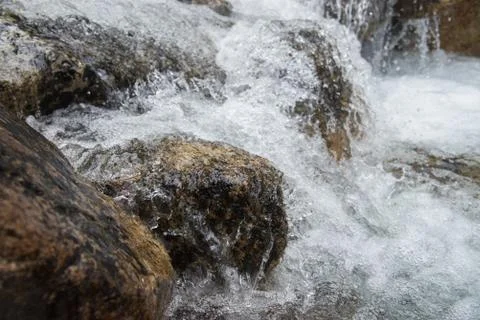Splashes of water under mountain river, close up shot Stock Photos
