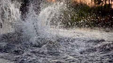 Splashes of water from under the wheels of a bicycle after sunset. The bike Stock Footage 141451802