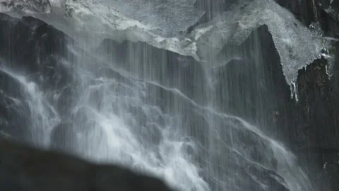 Splashes from the waterfall fall on the rocks. Video stock 209936110