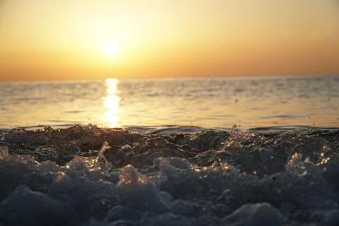 Splashes from the waves at sunset Stock Photos