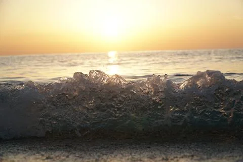 Splashes from the waves at sunset Stock Photos