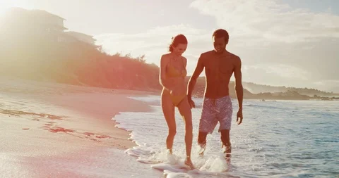 Splashing eachother on a golden beach Stock Footage 101345996
