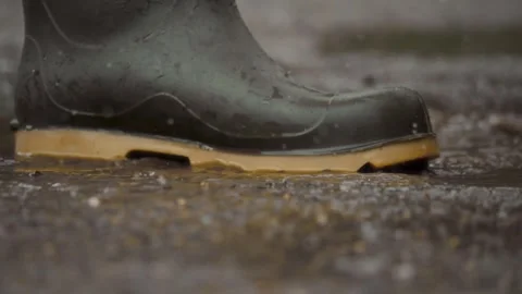 Splashing in Rain A CloseUp Shot Featuring Waterproof Boots in Action and Stock Footage 313283618