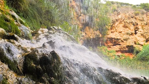 Splashing river waterfall in slow motion on green rock Stock Footage 124388972