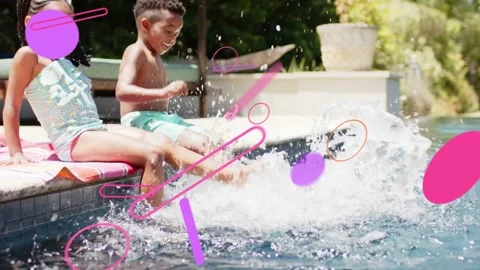 Splashing siblings on towel at pool edge, kicking in water, wearing swimsuit and 스톡 동영상 332934352