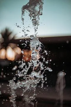 Splashing water from a fountain at sunset Stock Photos