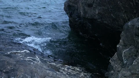 Splashing waves on black rocks, 4k, slow-mo Stock Footage 243529271