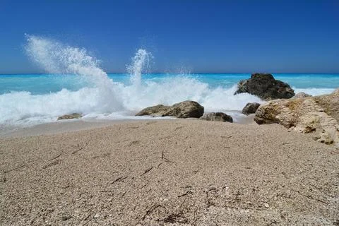 Splashing waves on empty beach Stock Photos