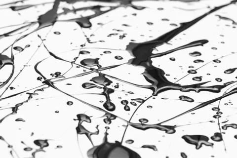 Splattered black paint making a complex abstract pattern on a white surface Stock Photos
