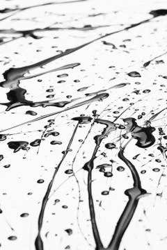 Splattered black paint making a complex abstract pattern on a white surface Stock Photos