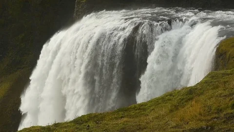 Splendid crest of a waterfall and a grassy foreground Stock Footage 74908298