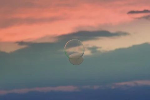 Splendid sunset and floating soap bubble filled with smoke. Stock Photos