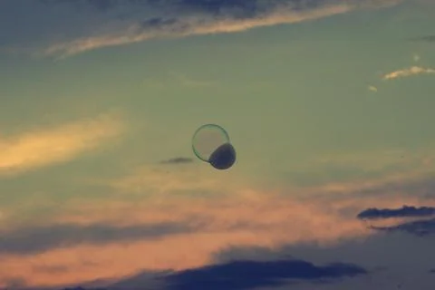 Splendid sunset and floating soap bubble filled with smoke. Stock Photos