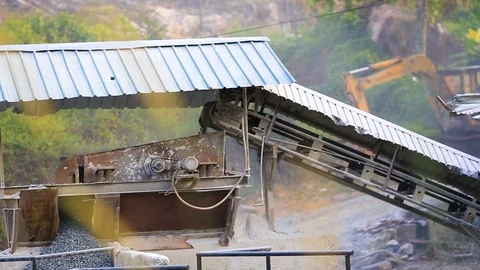 Splinters belt is rolling and dropping off gravels on the heap of rocks Stockbeeldmateriaal 74950127