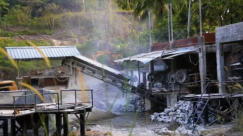 Splinters belt is rolling and dropping off gravels on the heap of rocks Stockbeeldmateriaal 74950329