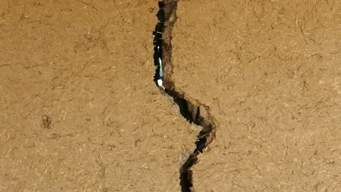Split and cracked adobe wall, wall slit, damaged adobe wall, village wall, Video stock 225524747