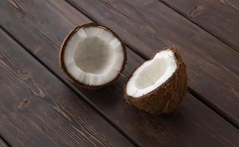 Split coconut on wooden planks. Coco, ripe palm fruit. 库存照片