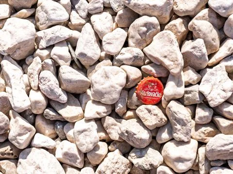 Split, Croatia - August 08, 2025: Red Karlovacko bottle cap among pale beach Stock Photos