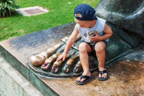 SPLIT, CROATIA- SEPTEMBER 02 2008 : A little boy touches a bronze statue of B Stock Photos