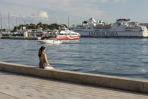 Split, Croatia, September 24th 2019. A girl in a dress looking at the sea 스톡 사진