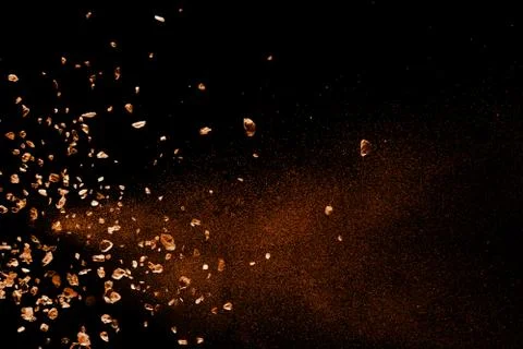 Split debris of stone exploding against black background. Stock Photos